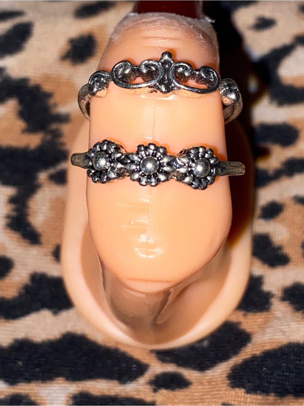 Silver ring with three floral designs and a ring with a unique design